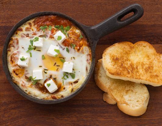 BREAKFAST الألفطار المميز Shakshuka; freshly baked eggs over tomato and red pepper sauce.